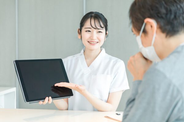 歯科衛生士が患者様とコミュニケーションをとっている写真。